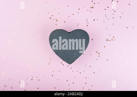 Black gift box on pink background with gold sequins Stock Photo