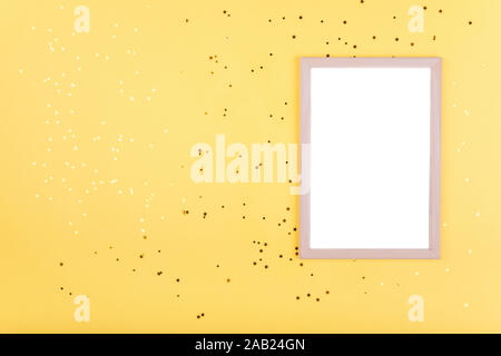 White frame on yellow background with gold sequins Stock Photo