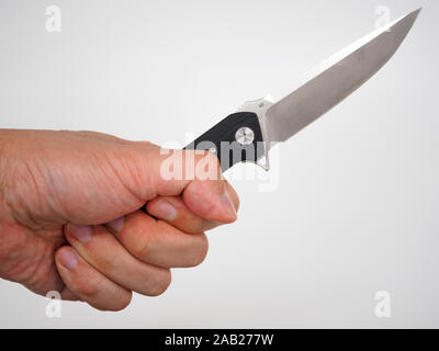 Hand holds pocket / folding / utility / knife isolated on white background Stock Photo