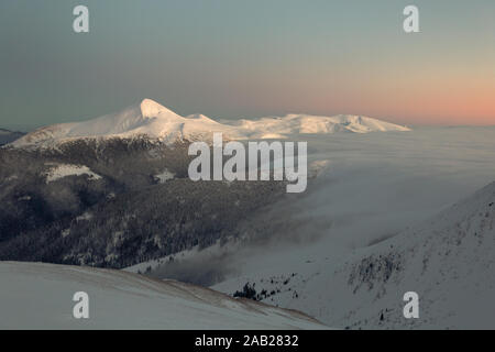 Soft pink sunset on top of a winter mountain Stock Photo