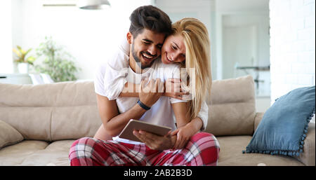 Cute couple relaxing on couch with tablet at home Stock Photo
