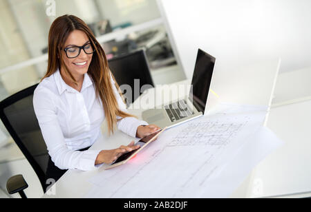Female designer in office working on architects project Stock Photo