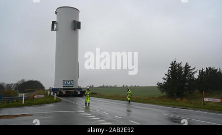 Hanstholm, Denmark, 25th November 2019: The 22-kilometer-long route from the port of Hanstholm to the installation site, the test center for windmills at Østerild, is closed by local police to ensure a clear and safe route for the 28-meter-high and 8-meter-wide windmill section that is being moved in upright position. Using SPMTs for the transport ensures the stability, integrity and safety of the upright load over uneven roads and inclinations. Credit: Brian Bjeldbak/Alamy Live News Stock Photo