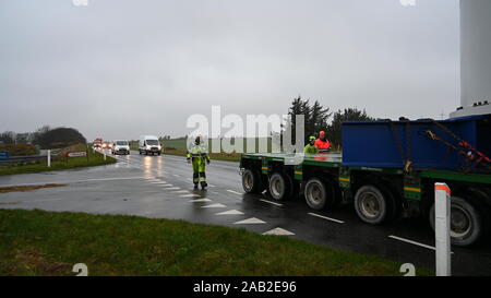 Hanstholm, Denmark, 25th November 2019: The 22-kilometer-long route from the port of Hanstholm to the installation site, the test center for windmills at Østerild, is closed by local police to ensure a clear and safe route for the 28-meter-high and 8-meter-wide windmill section that is being moved in upright position. Using SPMTs for the transport ensures the stability, integrity and safety of the upright load over uneven roads and inclinations. Credit: Brian Bjeldbak/Alamy Live News Stock Photo
