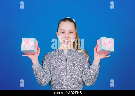 Black friday. Shopping day. Cute child carry gift boxes. Surprise gift box. Birthday wish list. World of happiness. Pick bonus. Special happens every day. Girl with gift boxes blue background. Stock Photo