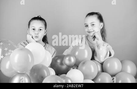 Carefree childhood. Sisters organize home party. Having fun concept. Balloon theme party. Girls best friends near air balloons. Start this party. Birthday party. Happiness and cheerful moments. Stock Photo