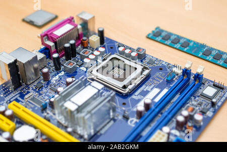 LGA socket on motherboard close-up. Blue motherboard. Processor and ram module beside. Stock Photo