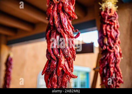 Red hot chili peppers ristras dried bunch hanging on a traditional building entrance, Santa Fe New Mexico Stock Photo