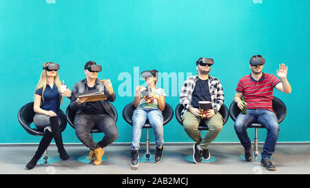 Group of friends using new technology playing on vr glasses indoor – virtual augmented reality with people having fun together Stock Photo