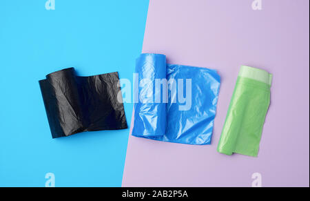 three rolled up rolls with plastic garbage bags on a blue background Stock Photo