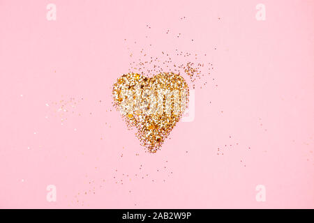 Heart shape made of golden glitter and stars on a pink background. Valentines day, love concept. Stock Photo