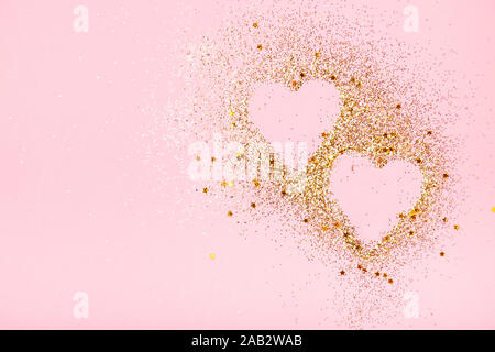 Two hearts made of golden glitter and stars on a pink background. Valentines day, love concept. Stock Photo
