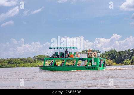 Typical tourist wildlife safari sightseeing boat underway sailing on the Victoria Nile, north west Uganda on a sunny day with rain clouds Stock Photo