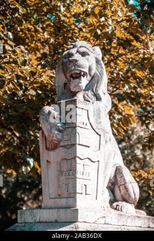 Stone lion statue in a park in Budapest. A stone lion statue in a park in Budapest. Autumn time Stock Photo