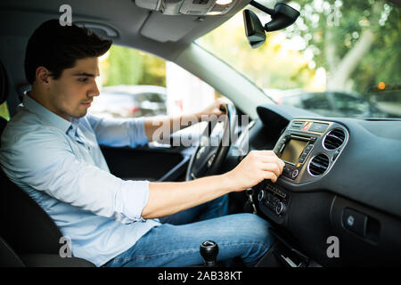 Man is going to drive, looking for some nice music Stock Photo