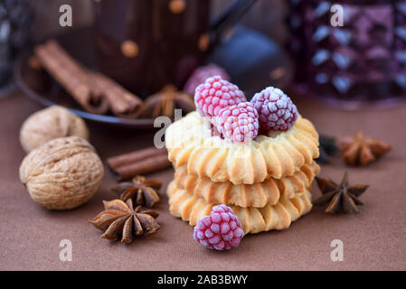 Shortbread cookies with frozen raspberries on brown background Stock Photo