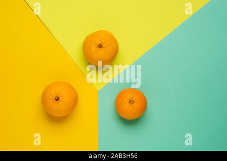 Christmas pattern. Christmas tangerines on colorful paper background with copy space for text. Flat lay, top view Stock Photo