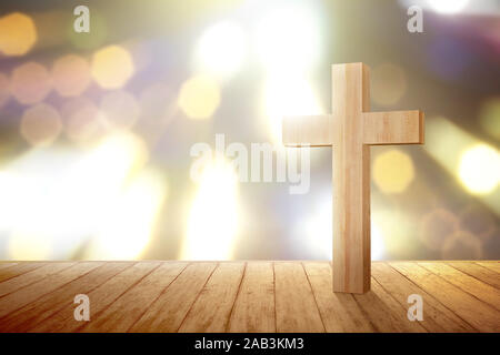 Christian cross on the wooden floor with blurred lights background Stock Photo