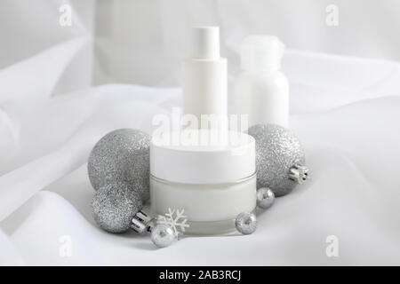 Set cosmetics, jar of winter cream for skin on white fabric background, closeup. Space for text Stock Photo