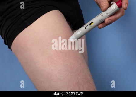 Eindhoven, the Netherlands, 12th November 2019. Humira, adalimumab. A man right after injecting himself in the leg with a pen and a needle to treat ps Stock Photo