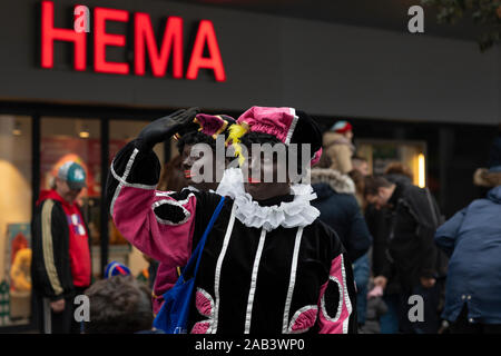 Eindhoven, The Netherlands, November 23rd 2019. Zwarte Pieten wearing colorful costumes with golden details smiling and waving at the children to welc Stock Photo