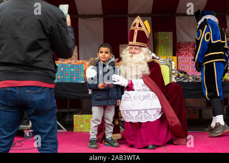 Eindhoven, The Netherlands, November 23rd 2019. Sinterklaas wearing his costume and having  a little boy next to him while posing for the camera and g Stock Photo