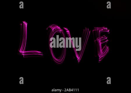 Love' word written in pink light on black background. Long exposure neon  light photograph. February 14 Valentine's Day concept. Neon wallpaper Stock  Photo - Alamy