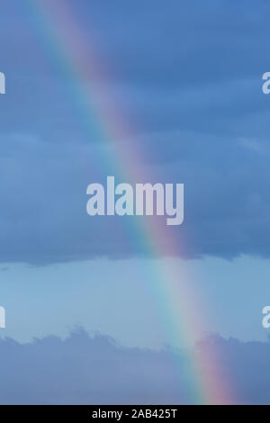 A piece of rainbow in the sky against the background of rain clouds ...