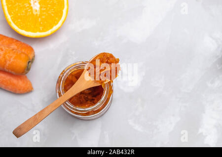 Jar of carrot jam made of sugar, carrots and oranges on concrete kitchen table Stock Photo