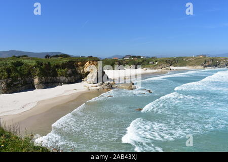 Beach with cliff, white sand and waves. Viveiro, Lugo Province, Spain. Stock Photo