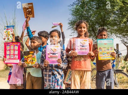 Children showing their schoolbooks in a village in India Stock Photo