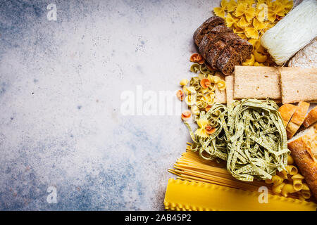 Various pasta background. Bread and different types of pasta on a gray-blue background, copy space. Stock Photo