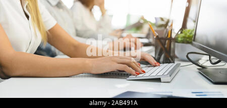 Female hands typing on computer keyboard at workplace Stock Photo