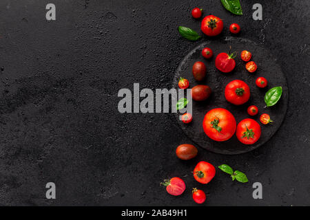 Cherry tomatoes minimalism picture on black background Stock Photo