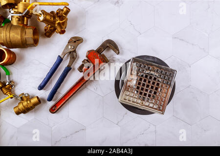 Closeup of a drain in shower room monkey wrench in the plumbers fixtures Stock Photo