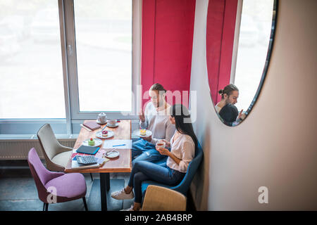 Entrepreneurs feeling good while tasting desserts and discussing menu Stock Photo