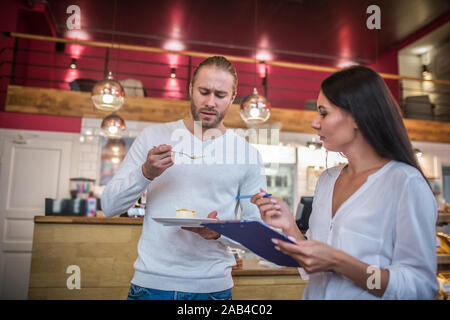 Couple owning cafeteria feeling not really satisfied with the dessert Stock Photo