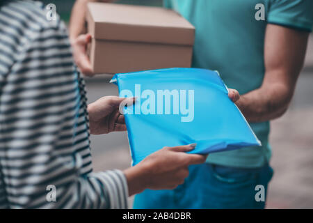 Woman taking her parcel while meeting delivery man Stock Photo