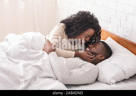 Romantic african couple kissing in bed, enjoying spending time together Stock Photo