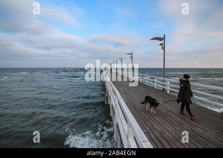 Mechelinki, Poland 23rd, Nov. 2019 Fishermen and environmentalists alert that due to the discharge of brine into the sea, fish get sick and die. Every third fish in the Bay is sick, has eye tissue atrophy,  and wounds on the body.  People walking on the pier near a pipeline dumping brine into the Puck Bay (Baltic Sea) from cavern rinsing for the state-owned gas company PGNiG are seen  © Vadim Pacajev / Alamy Live News Stock Photo