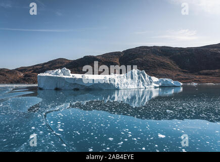 Bright sunny day in Antarctica. Full calm and reflection of icebergs in deep clear water. Travel by the ship among ices. Snow and ices of the Stock Photo