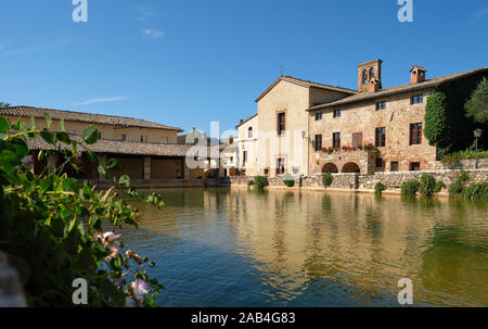 The ancient thermal bath village of  Bagno Vignoni and the Church of San Giovanni Battista in Val d'Orcia in Tuscany Italy - Baths of St. Catherine Stock Photo