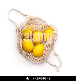 Fresh lemons inside reusable net bag isolated on white Stock Photo