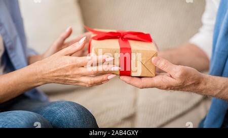 Presenting Christmas gift. Senior couple exchanging xmas presents Stock Photo