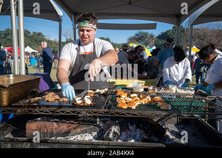 Austin, Texas, USA. 24 November, 2019. Peter works the wood fired grill for L'oca d'Oro showing off the Grilled Pork Shoulder Saltimbocca di Maiale with Capicola, Sage, Fresh Mozzarella & Pancetta Jam. WIne and Swine, an event put on by the Austin Food and Wine Alliance, was held at Camp Mabry, Sunday afternoon. Credit: Sidney Bruere/Alamy Live News Stock Photo