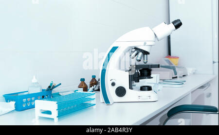 Close up of microscope on table with test tubes and other equipment Stock Photo