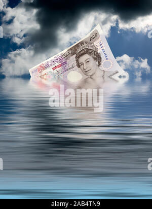 An English 20 pound note is sinking in the ocean Stock Photo