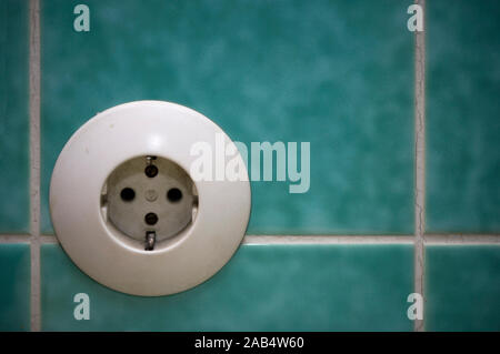 Old electrical socket on tiles in a bathroom Stock Photo