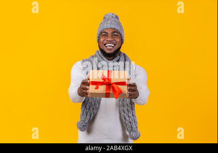 Cheerful young black man giving christmas gift Stock Photo