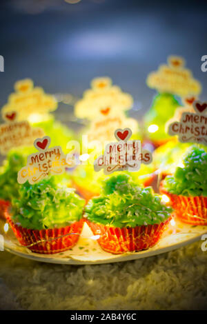 Christmas baking. Green Christmas cupcakes with the inscription Merry Christmas. Sweets for the Christmas table. Christmas sweets close-up. Stock Photo